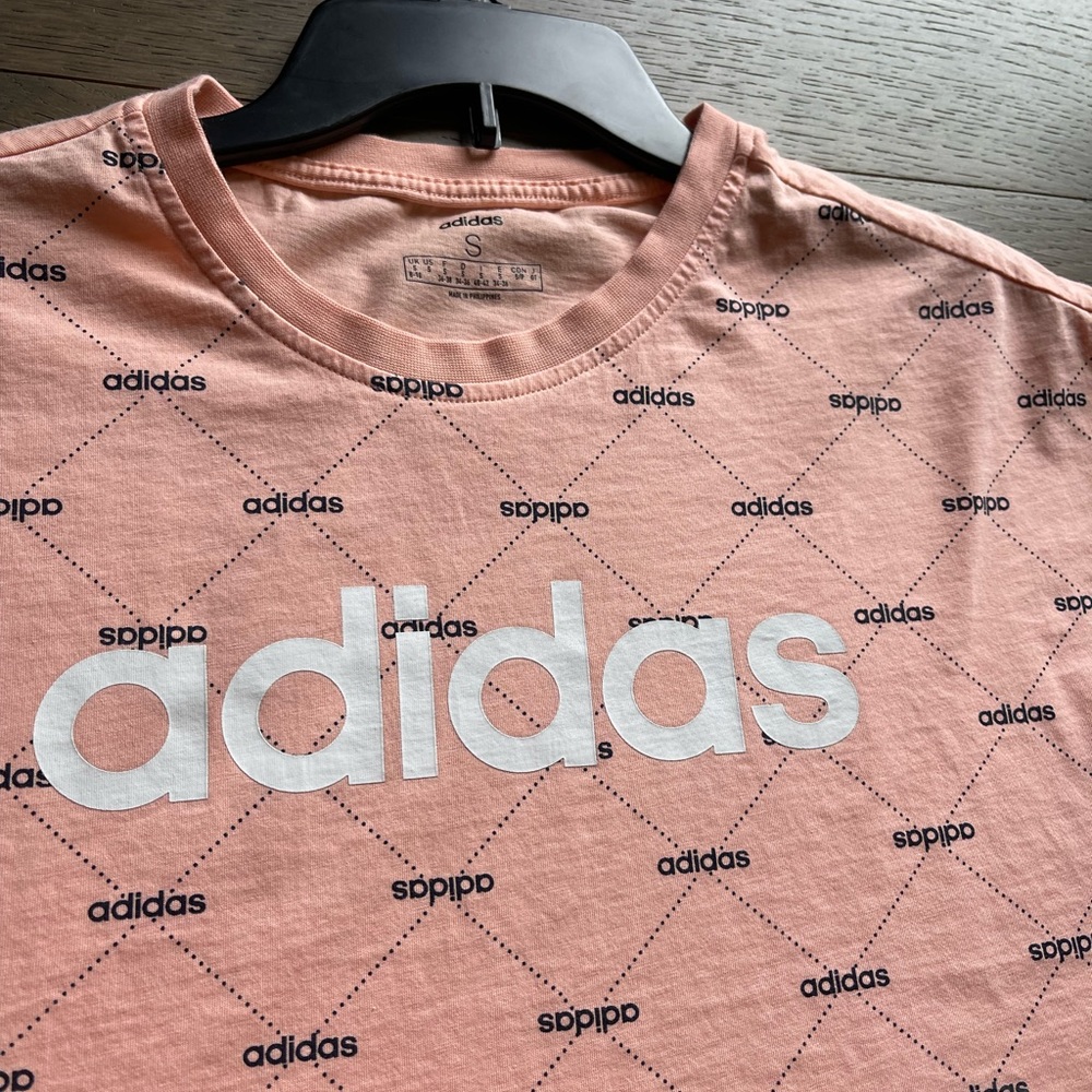 Womens adidas crop top shirt. Pink with adidas lettering throughout the shirt.